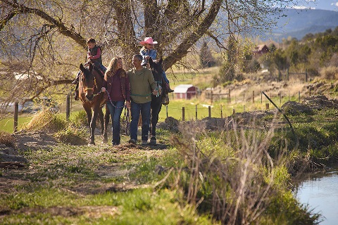 Eliese and Ron Ghaffari walk their two family horses with their children each riding horse back in Montrose, CO..