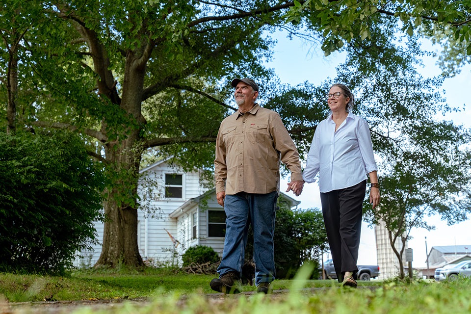 Rural 1st customers, Doug and Suzanne Harper, walk down their rural home's driveway.