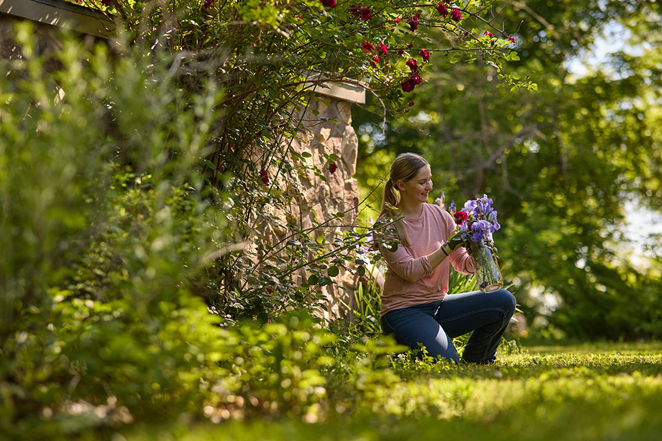 Woman tends to flowers on rural property financed by Rural 1st in Kansas